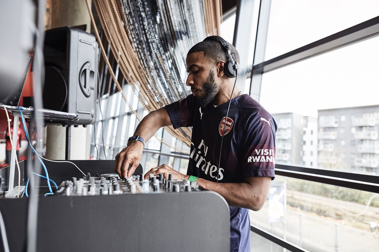 DJ T-Russ mixing music at the decks by a window