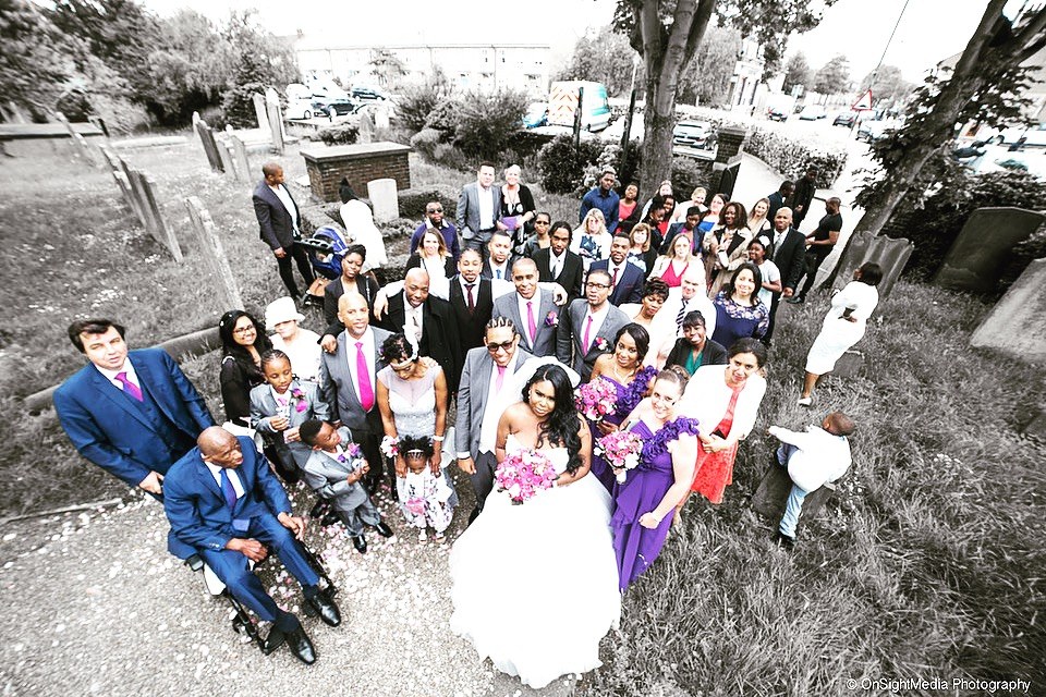 A wedding couple with their guests gathered for a group photograph